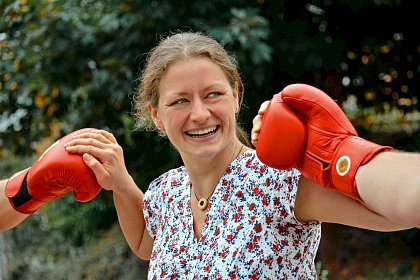 Photo: Social and Conflict Counseling Center 

(Photographer: Michael Deutsch)

[Image description: The photo shows Anke Märker laughing as she stands between 
two fists that have red boxing gloves on them. She is wearing a patterned blouse 
and has brown hair tied in a braid].